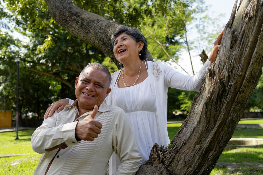 An older couple laughing together outdoors in a park